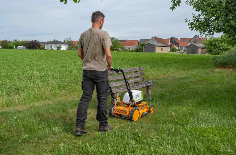AS-Motor AS 510 E-ProClip A AP in action mowing grass, young man walking behind the mower