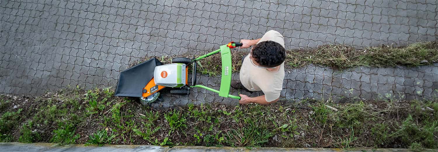 AS-Motor 30 E-Weedhex AP in action, topdown shot showcasing the mechanical weed removal on cobblestone