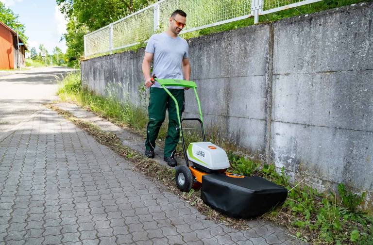 AS 30 E-WeedHex AP in action, brushing/removing weed on cobblestone