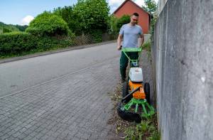 AS 60 E-WeedHex AP in action, brushing/removing weed on cobblestone
