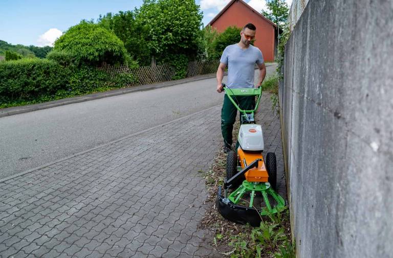 AS 60 E-WeedHex AP in action, brushing/removing weed on cobblestone