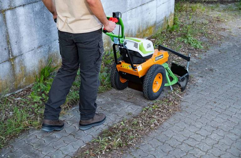 AS 60 E-WeedHex AP in action, brushing/removing weed on cobblestone