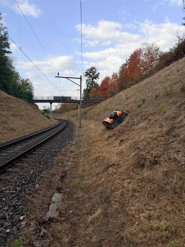 AS 990 Tahr RC mäht eine lange Böschung neben Bahngleisen und Oberleitungen